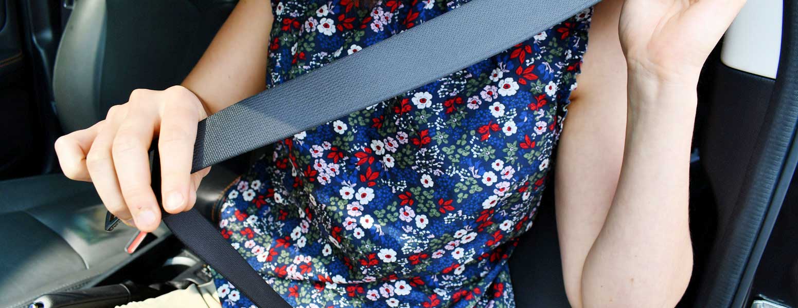 Woman putting a seat belt on