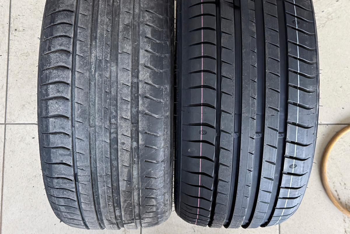 Two tires: one with low tread depth and one brand new.